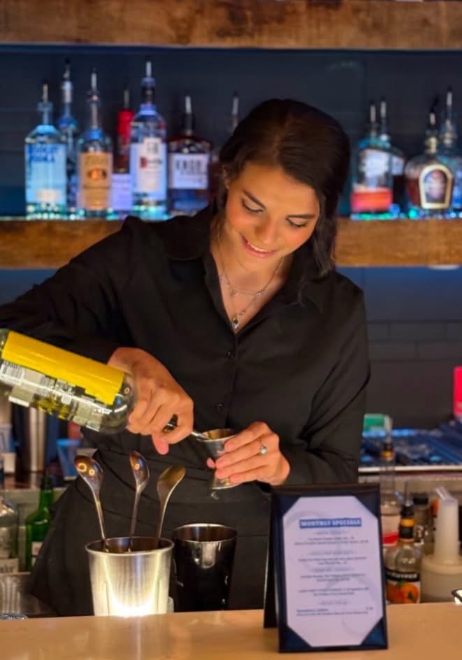 A 329 bartender mixing a cocktail at the rail
