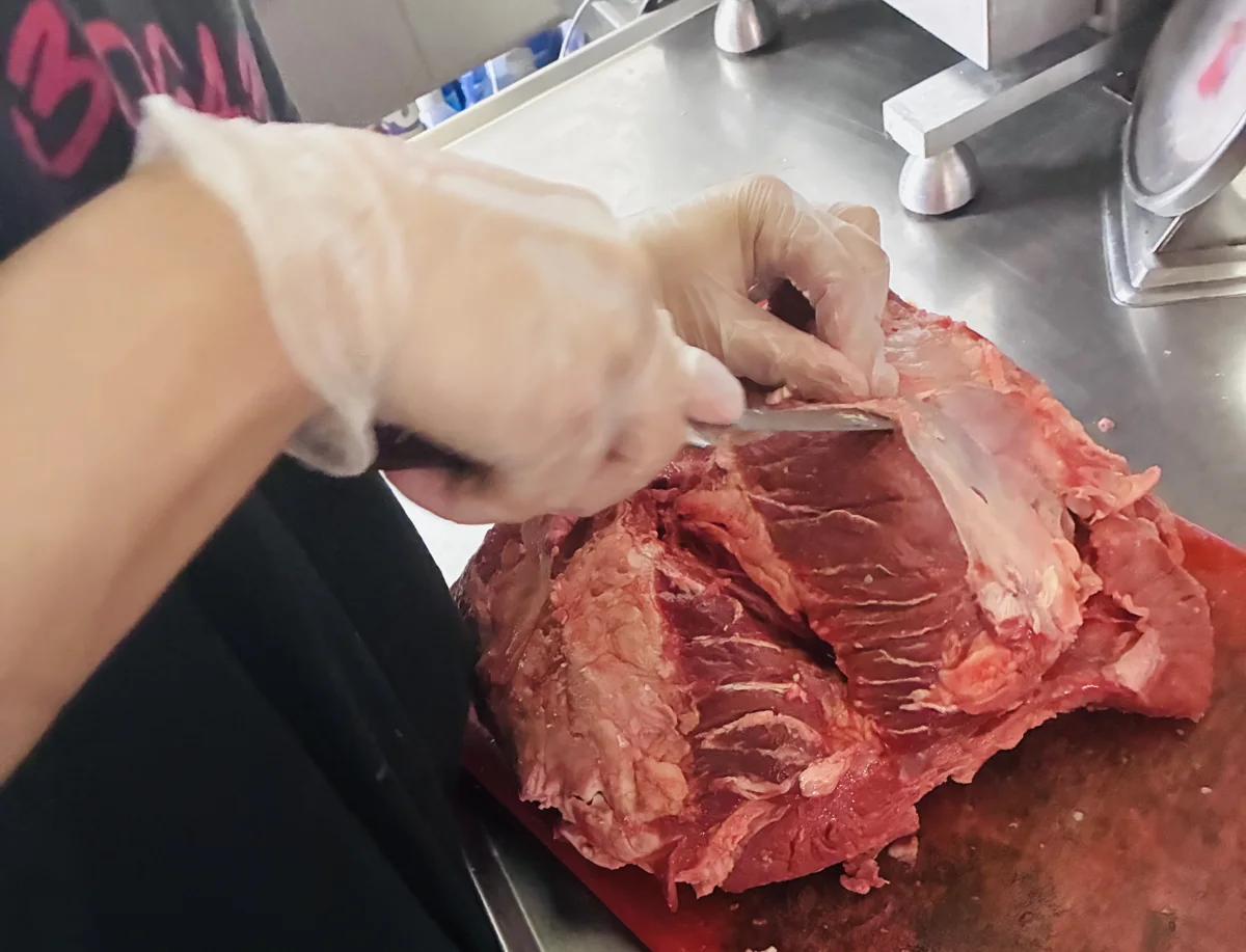 Trimming a steak by hand in the 329 kitchen